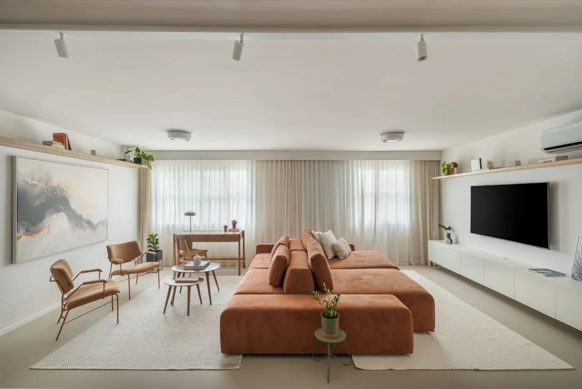 Sofá-ilha e materiais claros reorganizam apartamento em Higienópolis