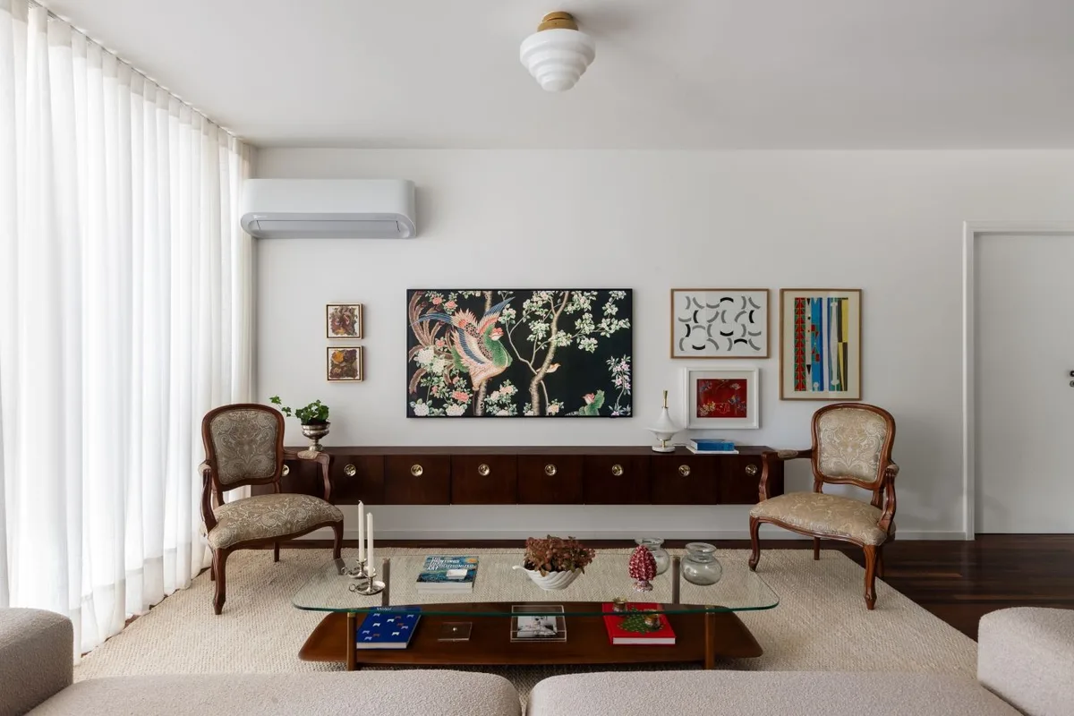Apartamento em Brasília reúne móveis de família, arte e madeira escura